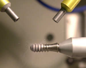 Texturing dental implants with Comco Automated MicroBlasting Systems.